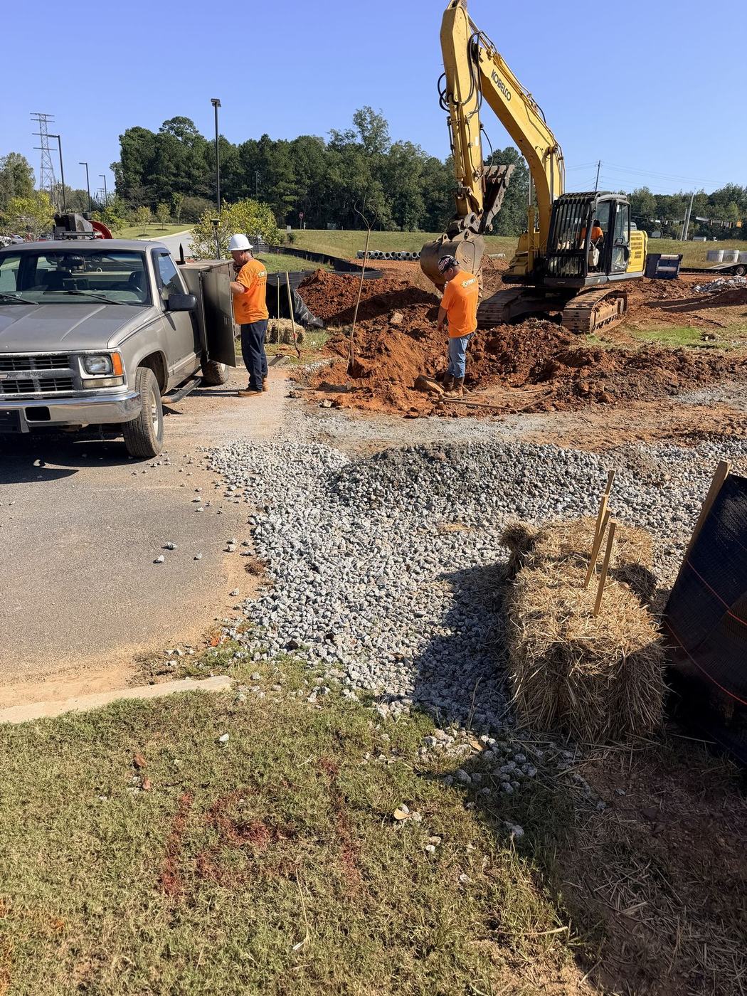 Stone construction entrance with straw bales next to an excavation